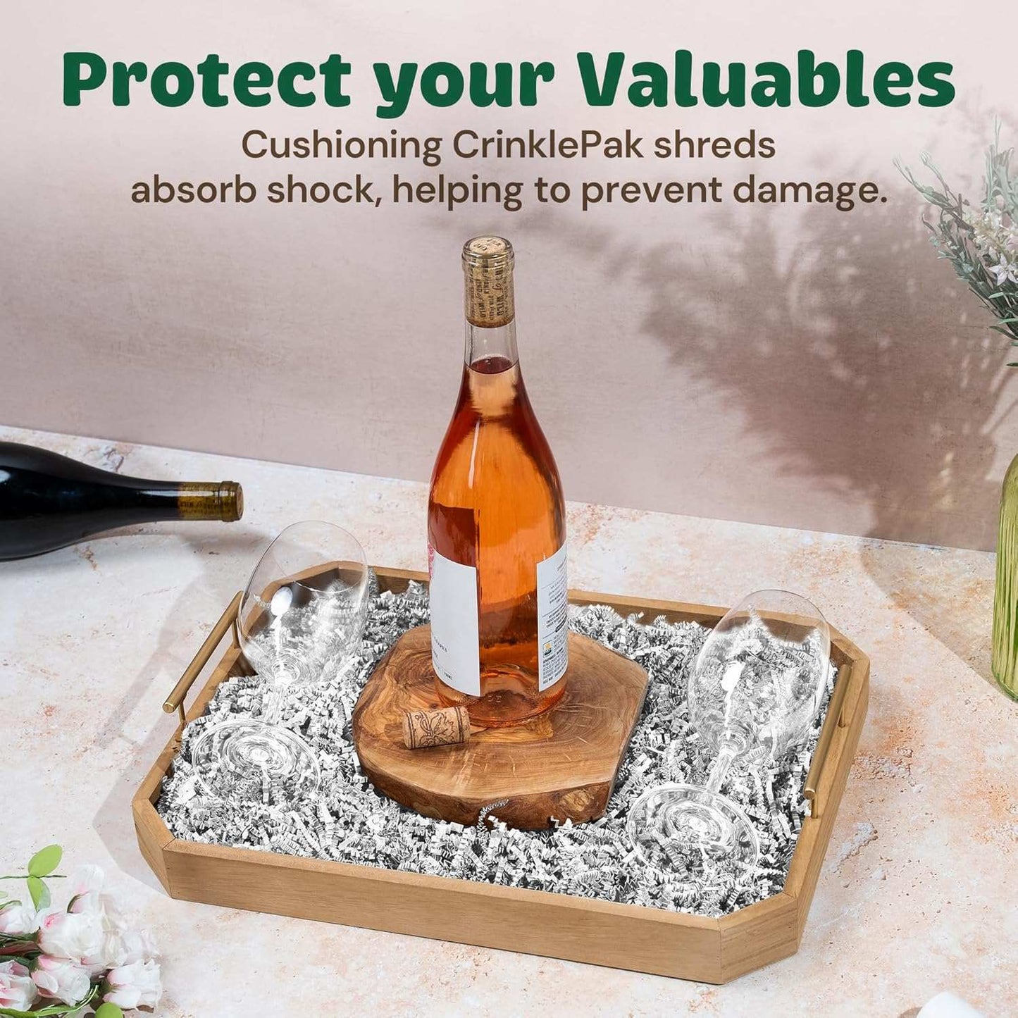 White crinkle paper cushioning a wine bottle and glasses in a wooden tray to protect valuables during packaging and shipping