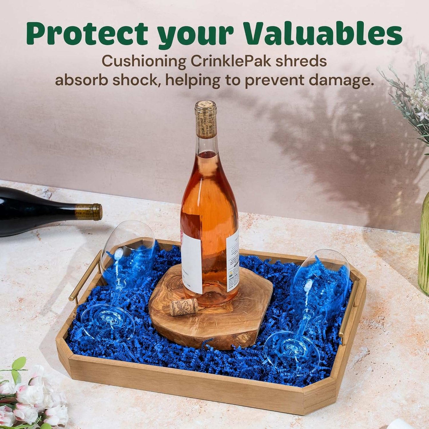 10 LB blue crinkle paper used as cushioning filler in a wooden tray with a bottle and glasses to protect valuables and prevent damage