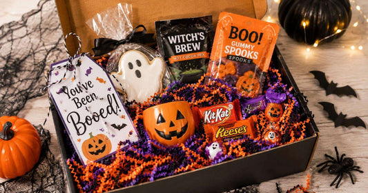 Halloween boo basket ideas for kids with candy, coloring book, crayons, glow sticks, stickers, and small toy on orange shred paper