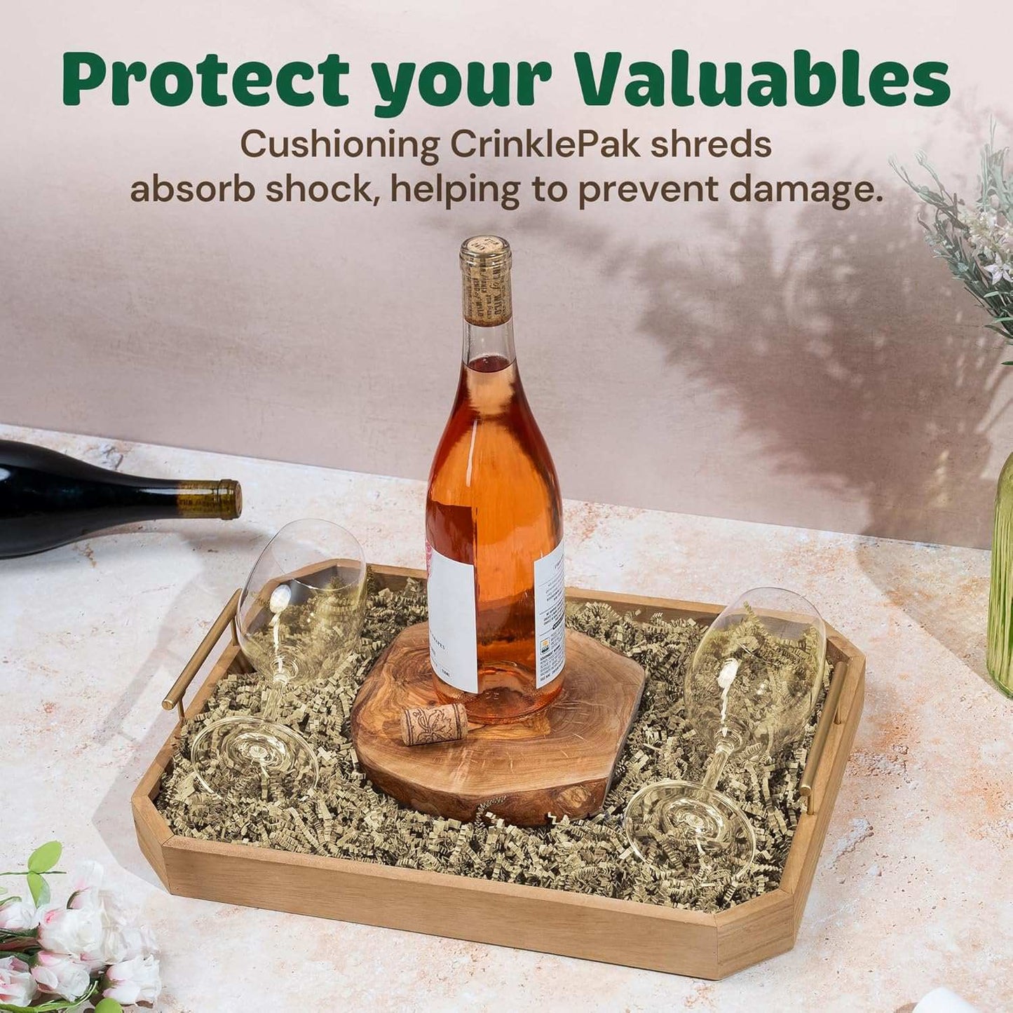 Ivory crinkle paper cushioning a bottle and glasses in a wooden tray for protective packaging.