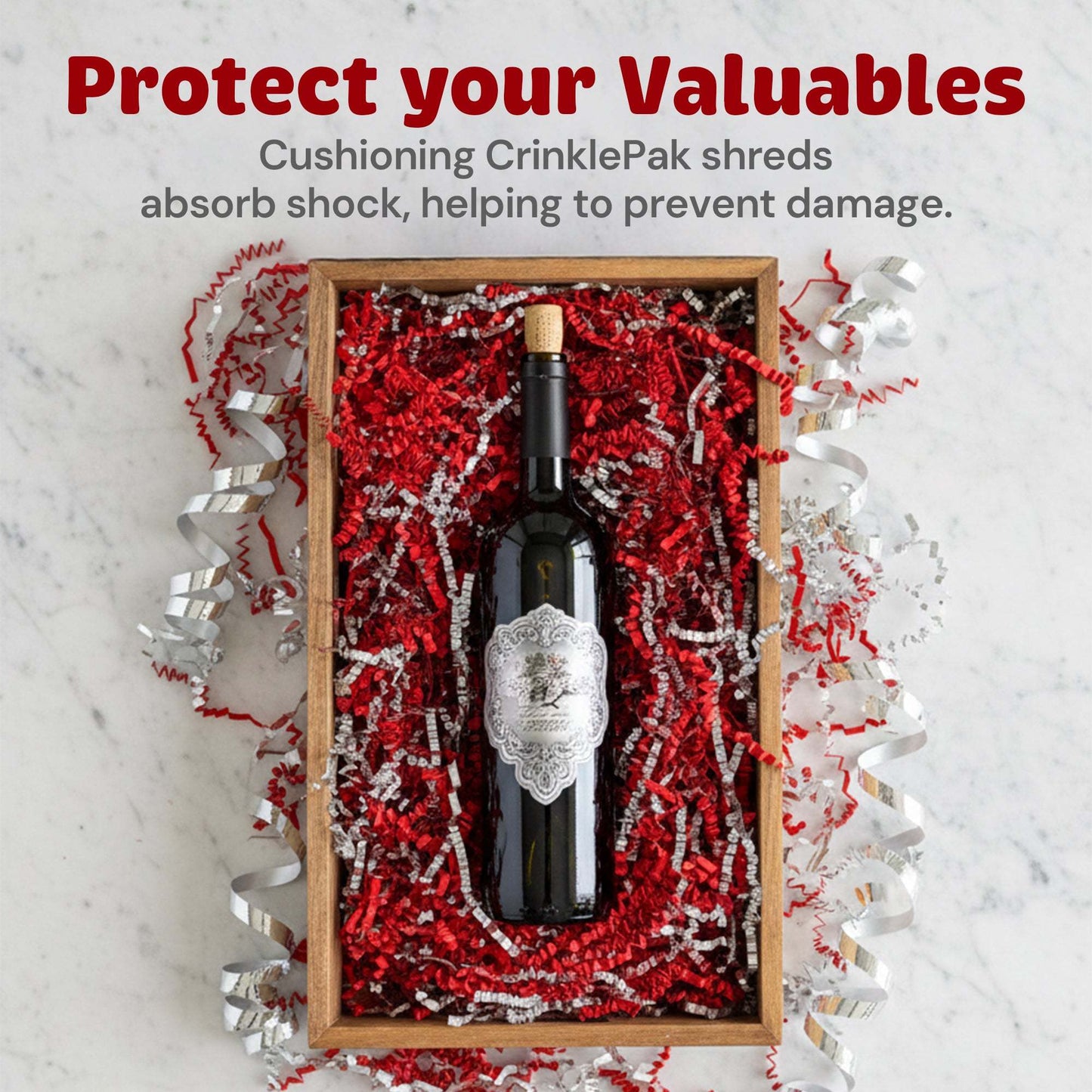 Premium red and silver metallic crinkle paper cushioning a wine bottle in a gift box